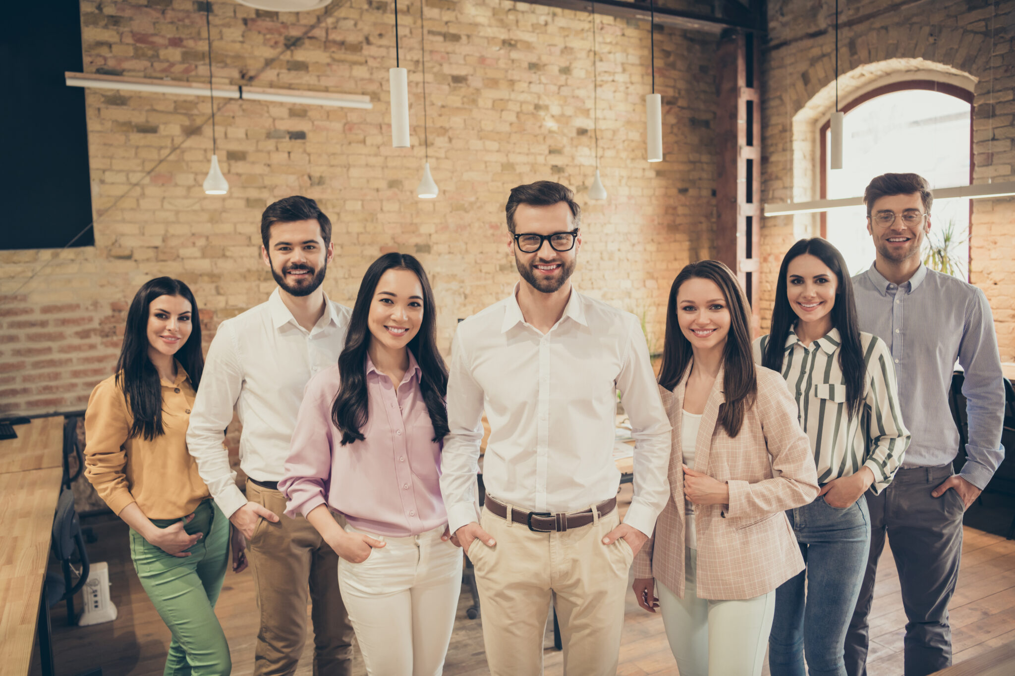 Photo of handsome business man pretty lady people partners stand, spacious big office seven members best friends successful teammates professionals good mood relationship indoors